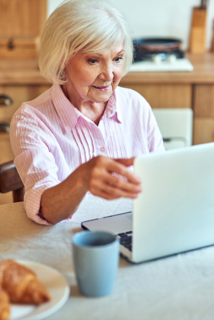 elderly woman looking at laptop